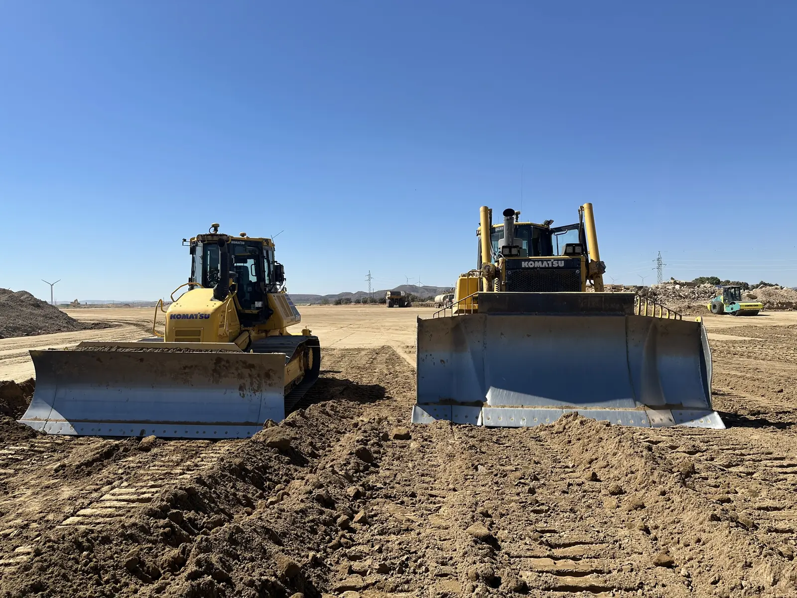 Dos bulldozers con antenas GNSS de control de maquinaria trabajando en una explanación